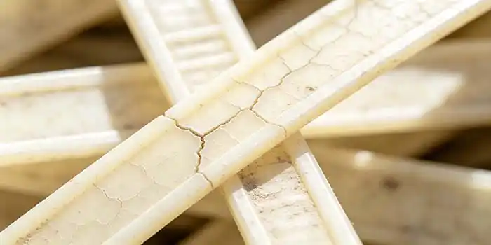 Close-up of a degraded nylon cable tie showing cracking and discoloration after outdoor exposure